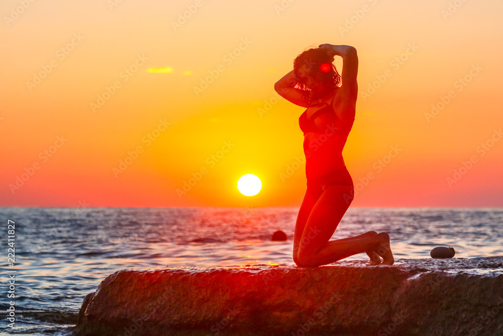 Silhouette of a girl at sunset on the sea