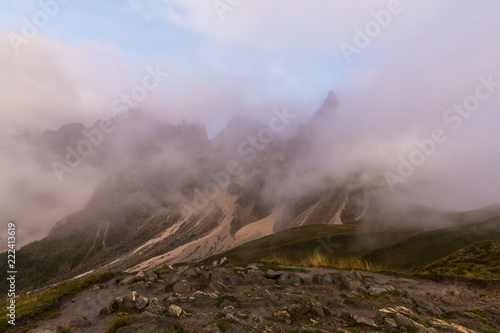 Dramatic clouds at sunset and mist in the Dolomite Mountains in autumn
