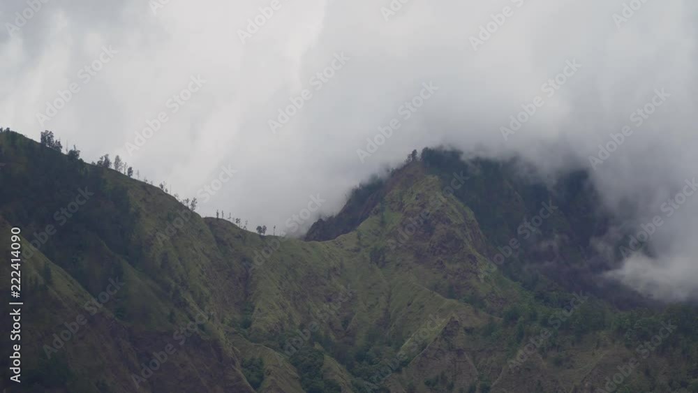 Tops of the mountains covered with forest in clouds and fog. Slopes of the mountains are covered with rainforest Bali, Indonesia. Mountain landscape, sky and clouds. Travel concept Tops of the mountains covered with forest in clouds and fog. Slopes of the mountains are covered with rainforest Bali, Indonesia. Mountain landscape, sky and clouds. Travel concept