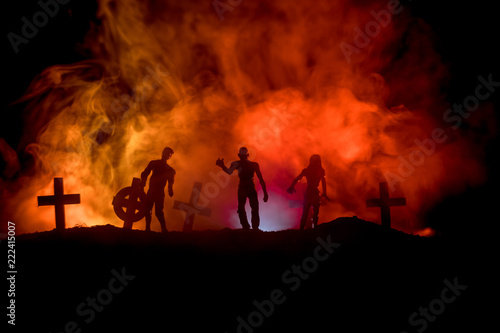 Scary view of zombies at cemetery dead tree, moon, church and spooky cloudy sky with fog, Horror Halloween concept.