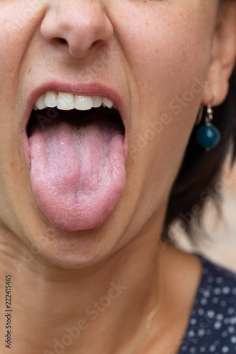 Close up of woman splitting tongue out of mouth photo