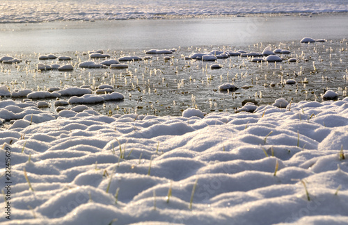 Snow at the edge of a flooded and ice-covered field