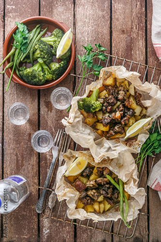 Traditional Greek kleftiko, an oven-baked lamb stew with potato, olive oil, onion, carrot, garlic and herbs, served with lemon and ouzo. photo