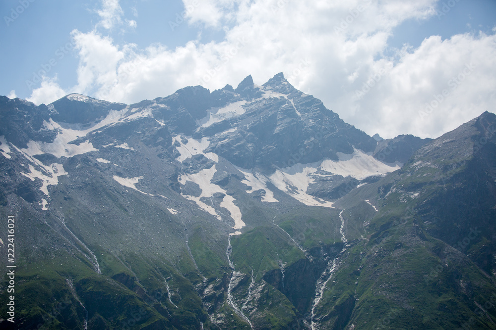 Obraz premium Photo of mountain slopes with vegetation and cloudy sky