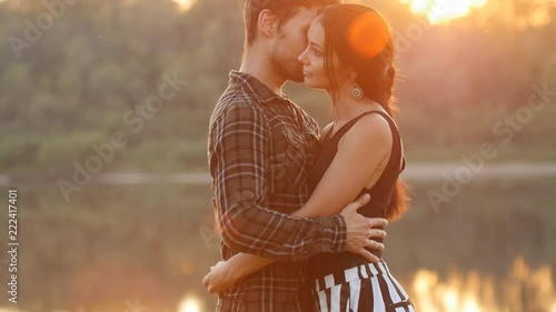 The concept of family and relationships. Young couple in love hugs at sunset photo