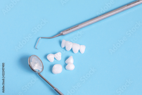Dental tools and zircon dentures on a blue sheet - Ceramic veneers - lumineers