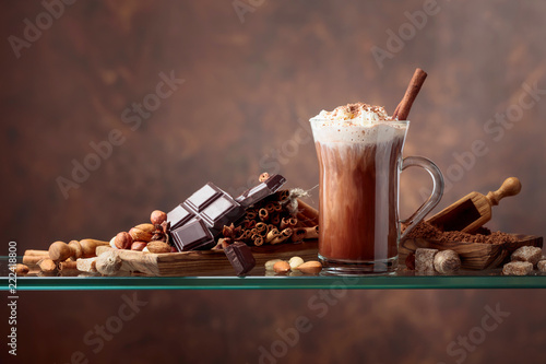 Valokuva Cocoa with cream, cinnamon, chocolate pieces and various spices.