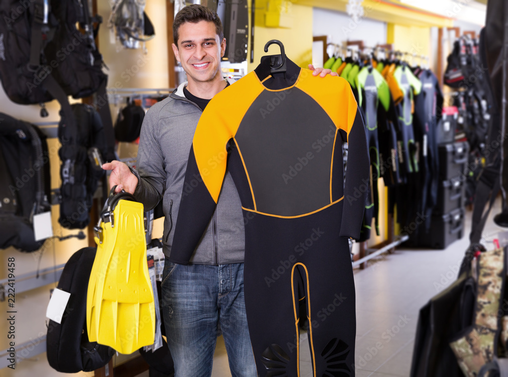 Smiling man  standing with sport diving costumes and flippers