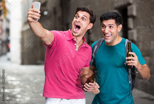 male fans are walking with beer and making selfie near sights in Barcelona photo