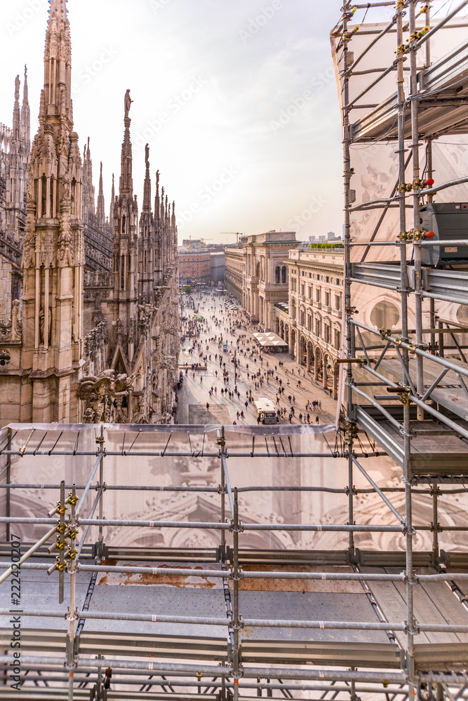 Vertical Rooftop view of spires, sculpture, cathederal, and construction on the Duomo di Milan