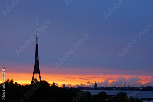 Summer sundown after storm in Riga, television tower on the front and trees and city buildings on the background on the horizon