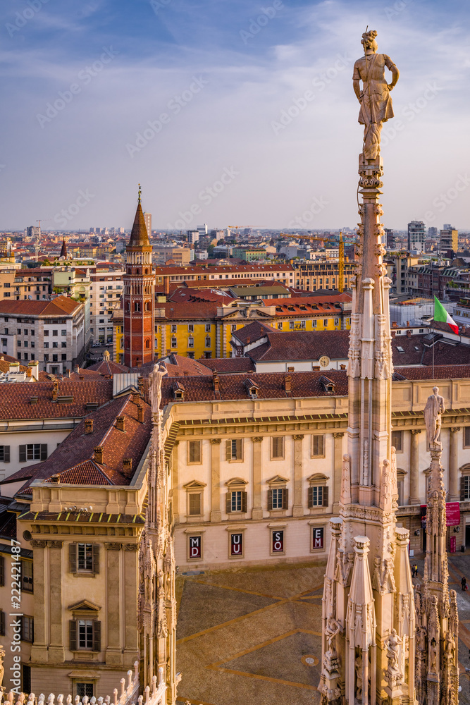 Vertical: Rooftop view of spires, sculpture, cathederal, and Milan from the Duomo di Milan