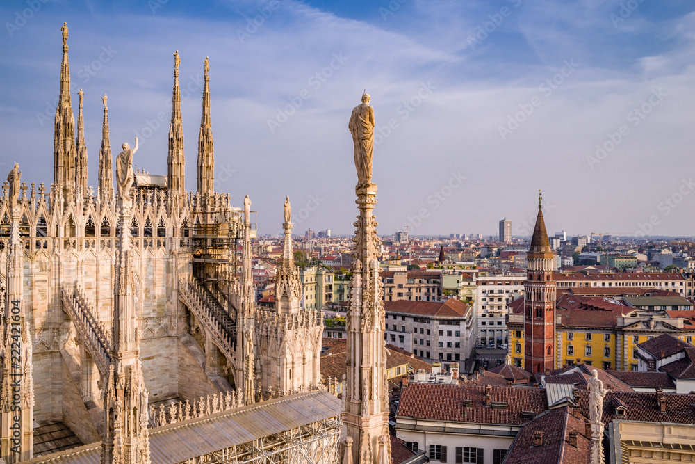 Rooftop view of spires, sculpture, cathederal, and Milan from the Duomo di Milano at sunset