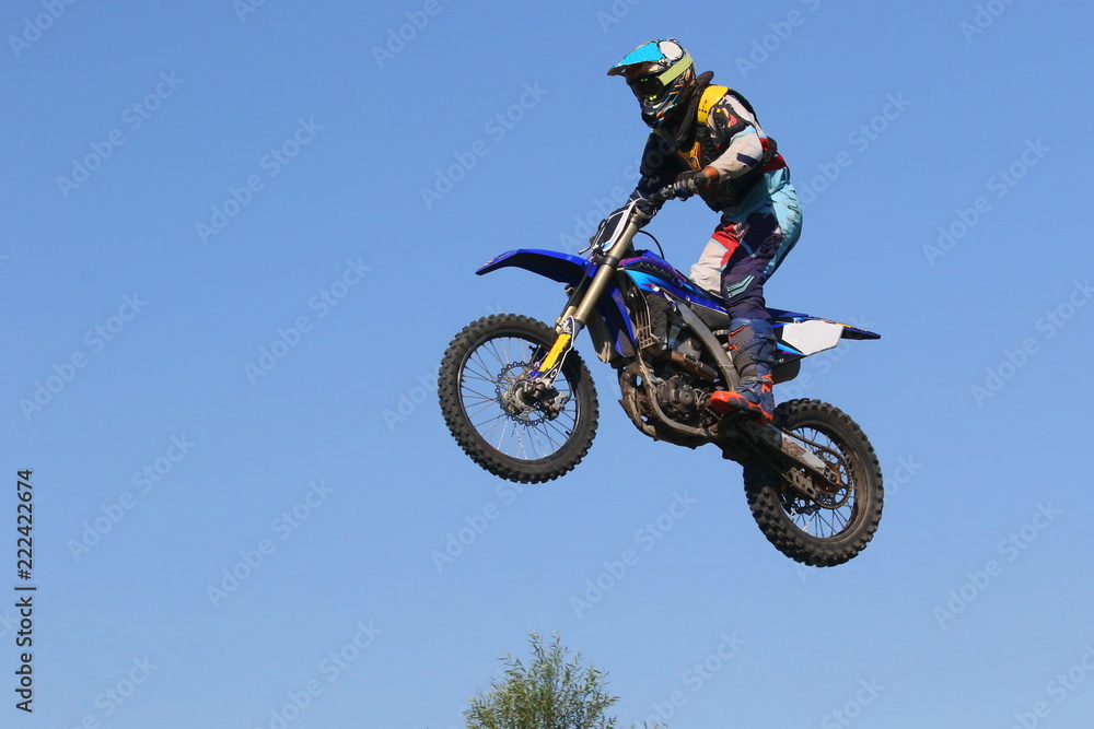 KYIV, Ukraine - august, 22, 2018. High flying motorcycle racer on blue sky background. Active extreme rest. KYIV, Ukraine - august, 22, 2018. High flying motorcycle racer on blue sky background. Active extreme rest.