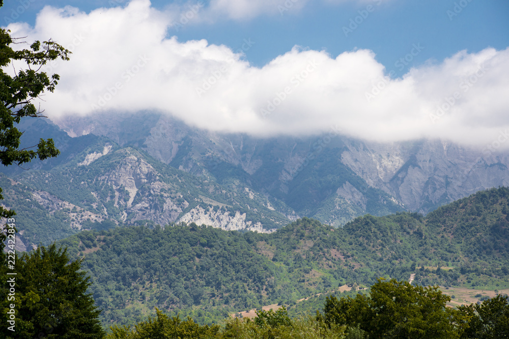 Majestic landscape of the mountains and forest in Caucasus at summer. Dramatic sky with clouds.