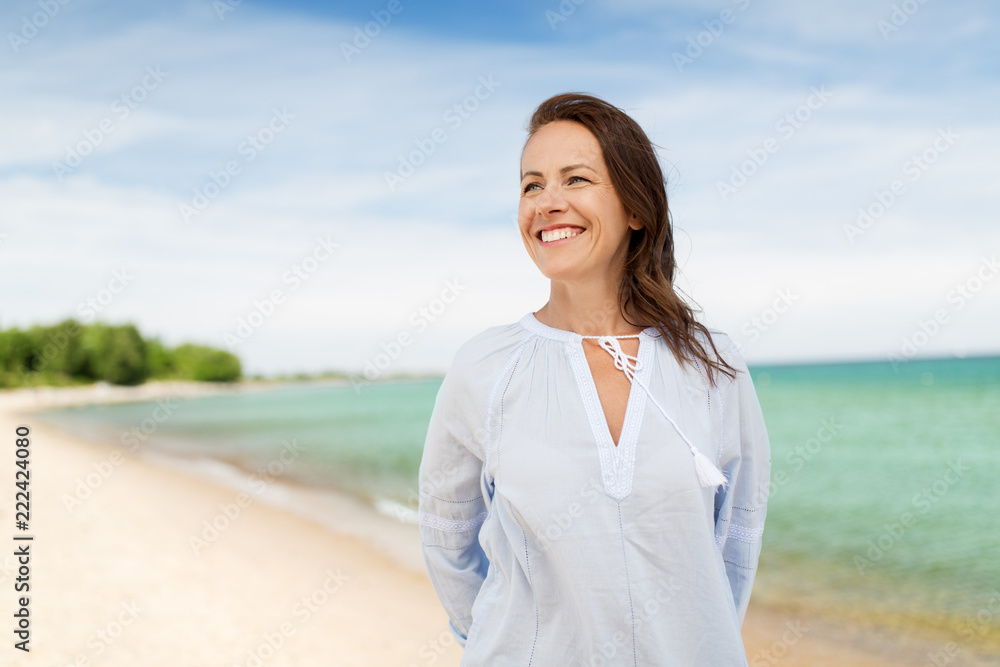 people and leisure concept - happy smiling woman on summer beach