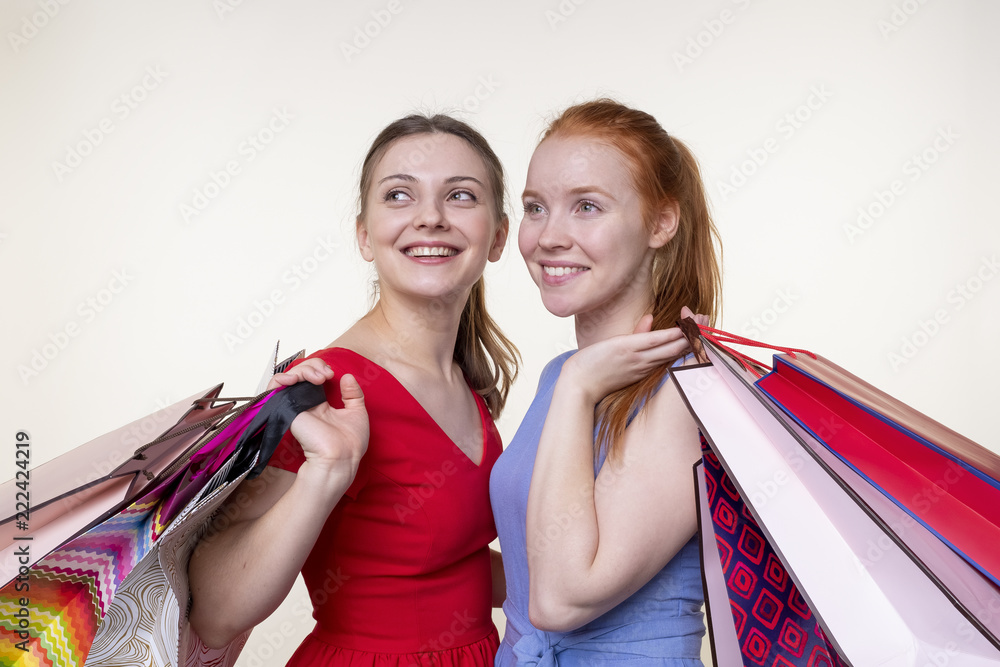 Two smiling beautiful young women holding paper bags Two smiling beautiful young women holding paper bags
