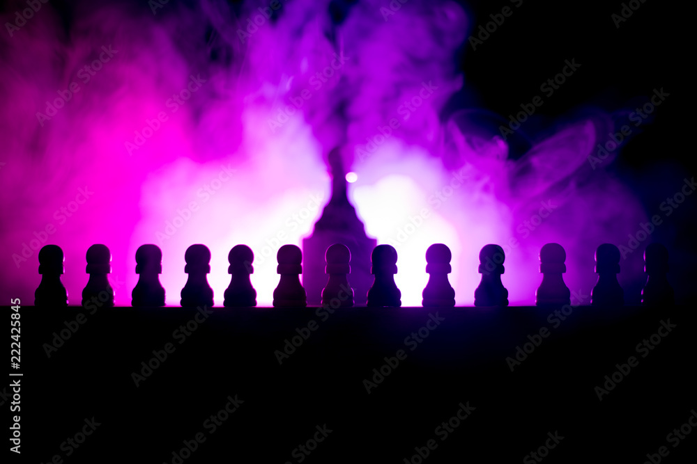 Chess board game concept of business ideas and competition or strategy ideas concept. Chess figures on a dark toned foggy background.