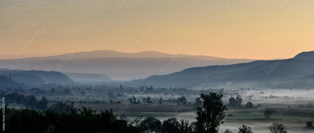 Autumn morning. Breathtaking morning lansdcape of small transylvanian village covered in fog.
