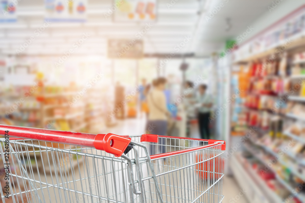 supermarket aisle blur abstract background with empty red shopping cart