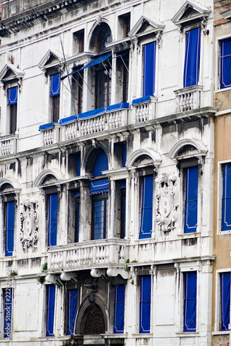 Vertical: Archetectural details of weathered colorful windows, doors, ornamentation, and balconies as seen from the Grand Canal in Venice, Italy photo