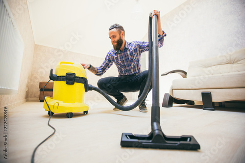 Young bearded man makes cleaning the house