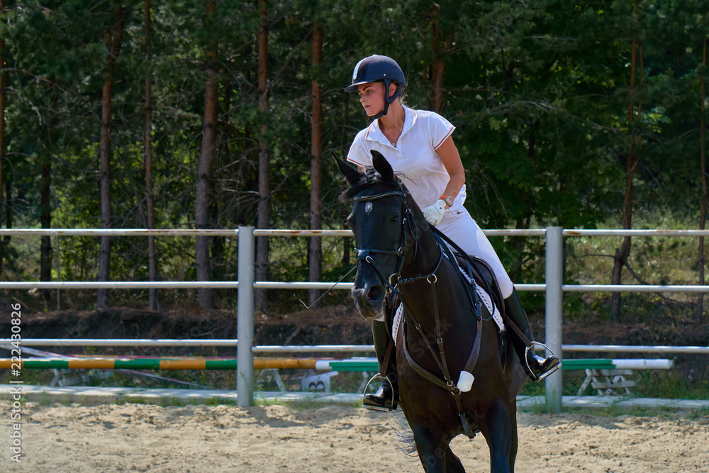 Young woman jockey in white dress and black boots, takes part in equestrian competitions. Close-up. Young woman jockey in white dress and black boots, takes part in equestrian competitions. Close-up.