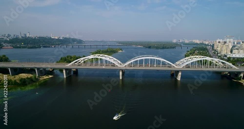 Aerial top view of automobile and railroad Darnitsky bridge across Dnieper river from above, Kiev city skyline photo