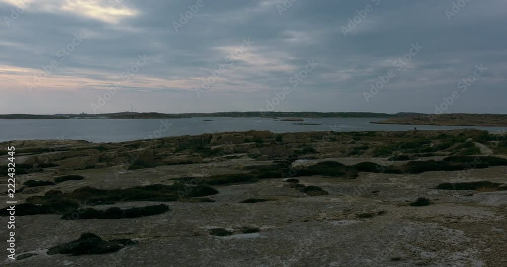 A tilting shot of a vast cliff landscape, ocean and pink sky. A tilting shot of a vast cliff landscape, ocean and pink sky.