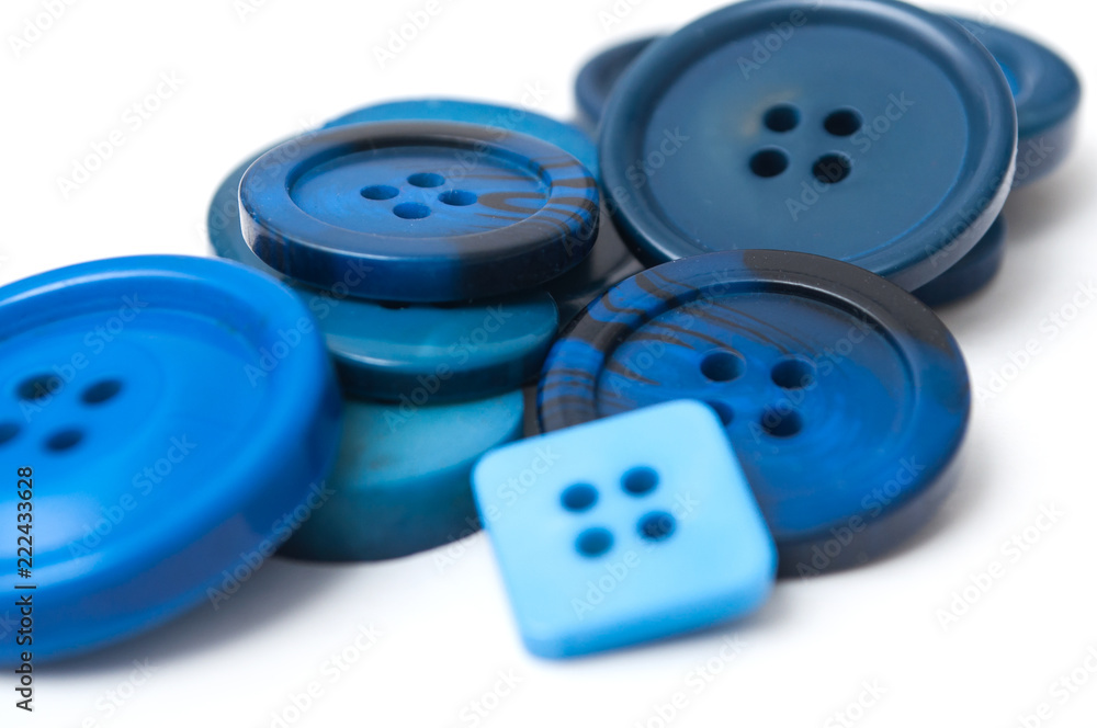 closeup of blue sewing buttons on white background closeup of blue sewing buttons on white background