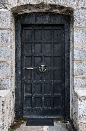 the old forged black door with the head of the eagle in the middle