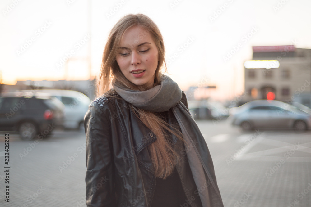 Portrait of a young woman with long hair in a jacket on the street Portrait of a young woman with long hair in a jacket on the street