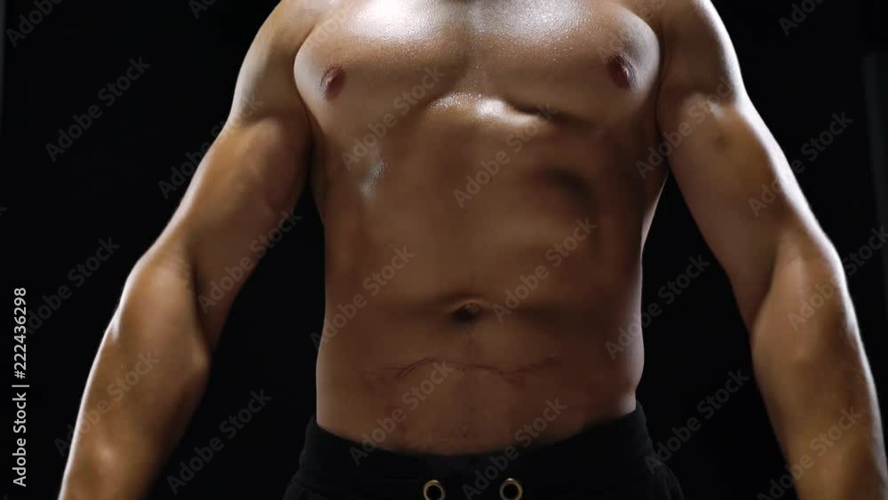 Man is doing exercises with a barbell, training on a black background in the studio Man is doing exercises with a barbell, training on a black background in the studio