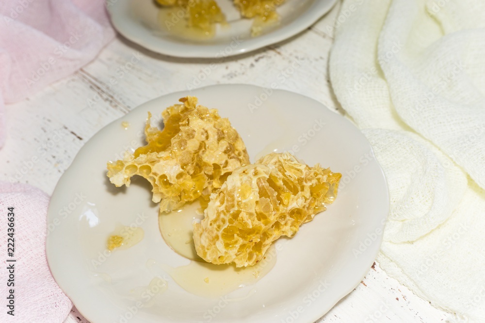 two white dessert plates with pieces of honeycomb on a light wooden background
two white dessert plates with pieces of honeycomb on a light wooden background