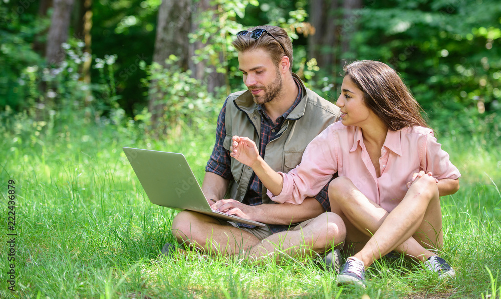Man and girl looking at laptop screen. Couple youth spend leisure outdoors with laptop. Modern technologies give opportunity to be online and work in any environment conditions. Freelance opportunity Man and girl looking at laptop screen. Couple youth spend leisure outdoors with laptop. Modern technologies give opportunity to be online and work in any environment conditions. Freelance opportunity