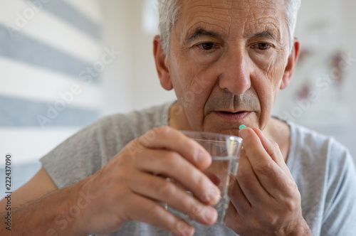 Senior man taking medicine Fototapet