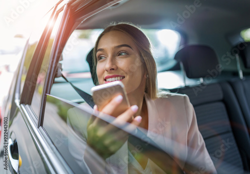 Woman with smart phone in a car
 photo