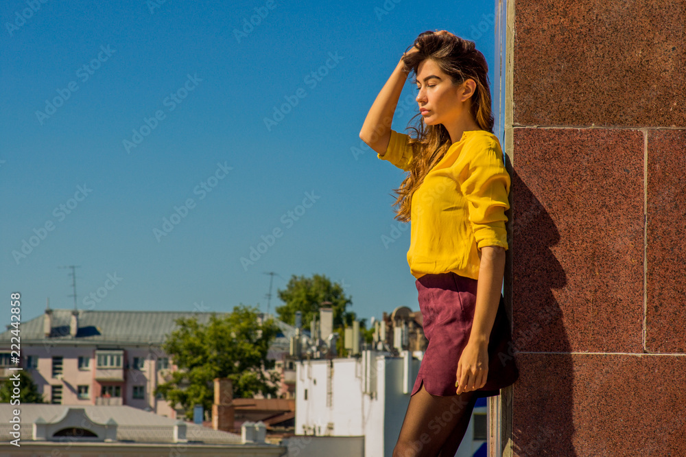 Girl with closed eyes under the sun rays against the sky