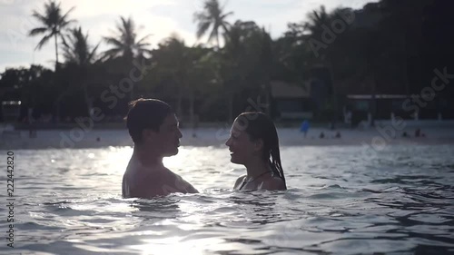 A couple in love rest on the sea, bathe in the water, not far from the shore, embrace in the rays of the passing sun. slow motion, HD, 1920x1080 photo