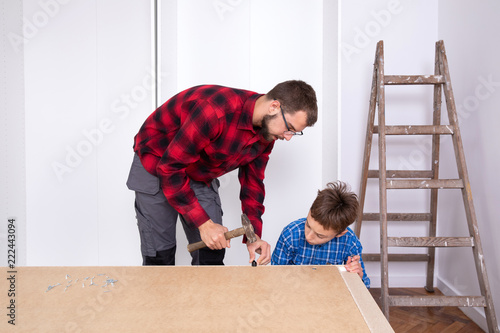 Young boys assembling furniture at home 