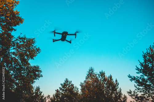 modern drone in the air at forest scene