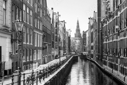Beautiful view of the famous Oudezijds Kolk in Amsterdam, the Netherlands, in black and white. In the background is the Oude Kerk (Old Church, 1213) in the Red Light District
