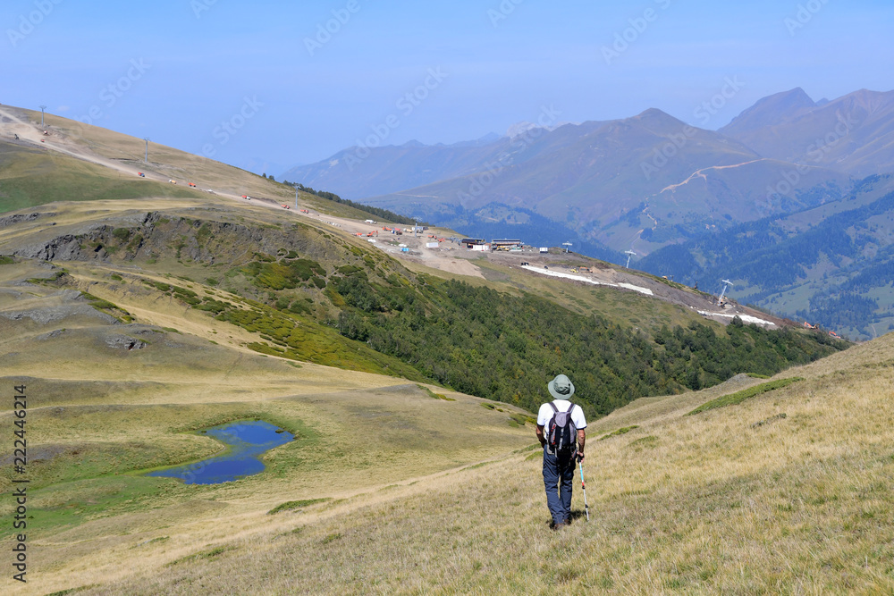 Arkhyz, Russia, Caucasus. Man on the plateau Gabulu  down to the small lake in sunny weather