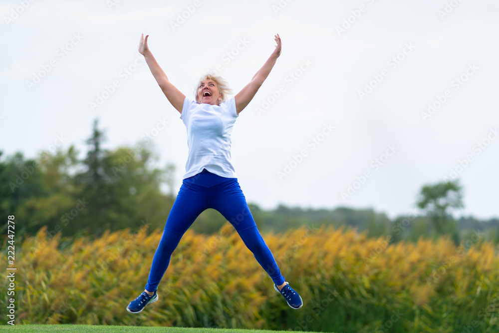 Woman jumping for joy with arms and legs spread Woman jumping for joy with arms and legs spread