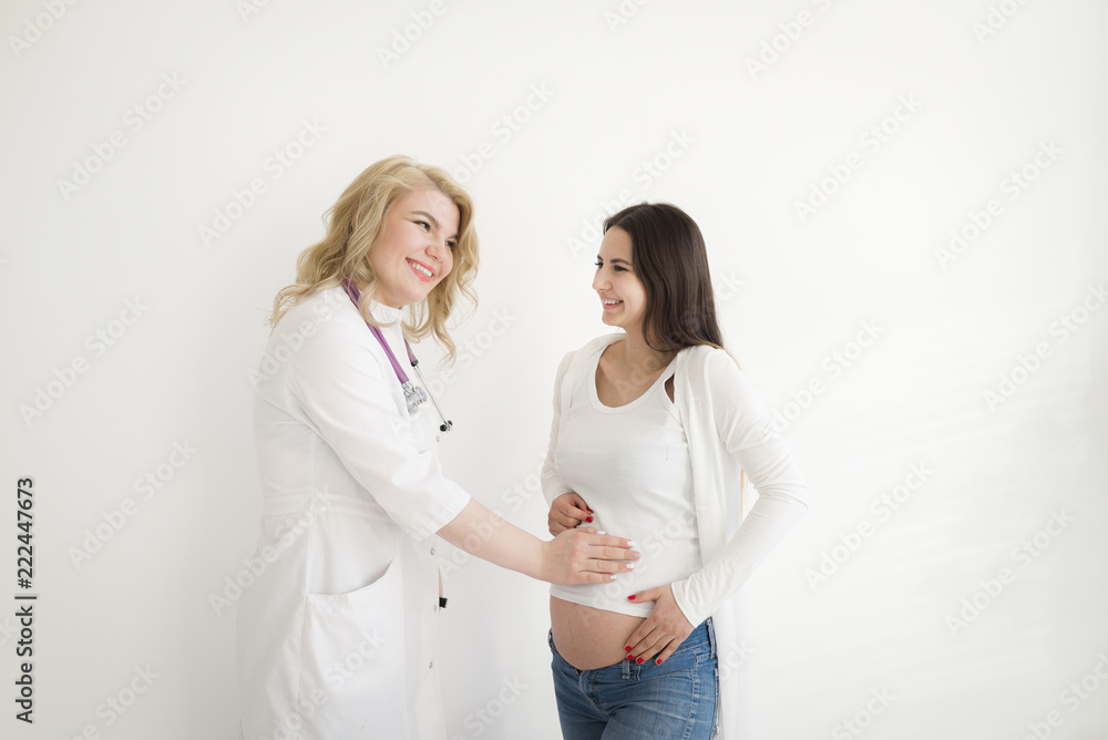 The doctor touches the belly of the pregnant woman. Examination of a pregnant woman. The doctor touches the belly of the pregnant woman. Examination of a pregnant woman.