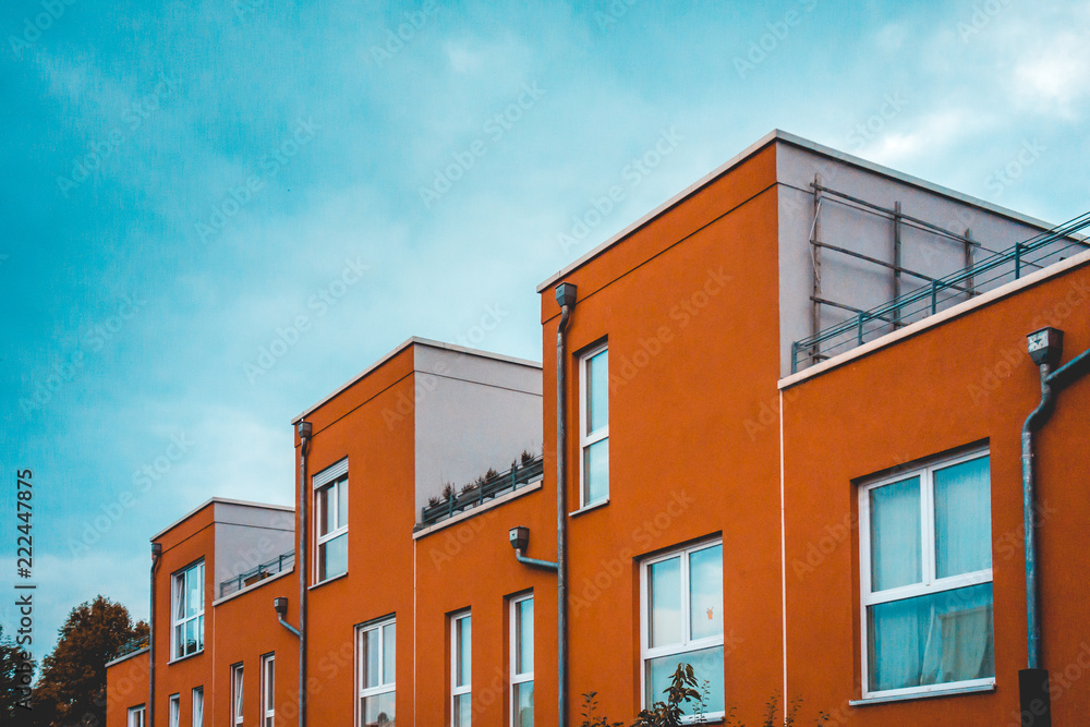 colorful picture of red townhouses with contrasted sky