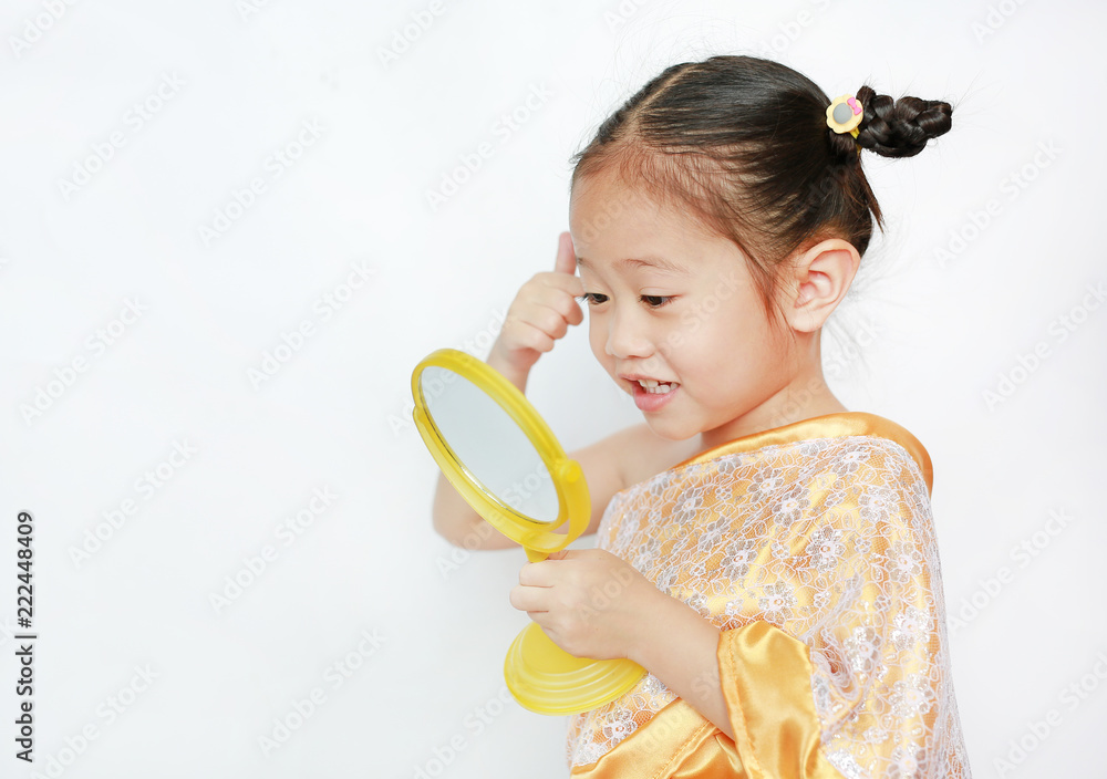 Portrait of asian child girl in traditional thai dress looking at mirror isolated on white background. Portrait of asian child girl in traditional thai dress looking at mirror isolated on white background.