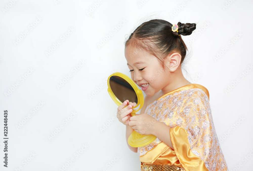 Portrait of asian child girl in traditional thai dress looking at mirror isolated on white background. Portrait of asian child girl in traditional thai dress looking at mirror isolated on white background.