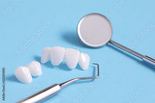 Zircon dentures samples on a blue sheet with dental tools - Ceramic veneers - lumineers photo