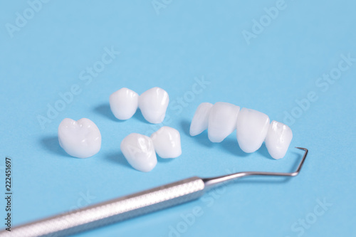 Dental explorer tool with zircon dentures on a blue sheet - Ceramic veneers - lumineers 
